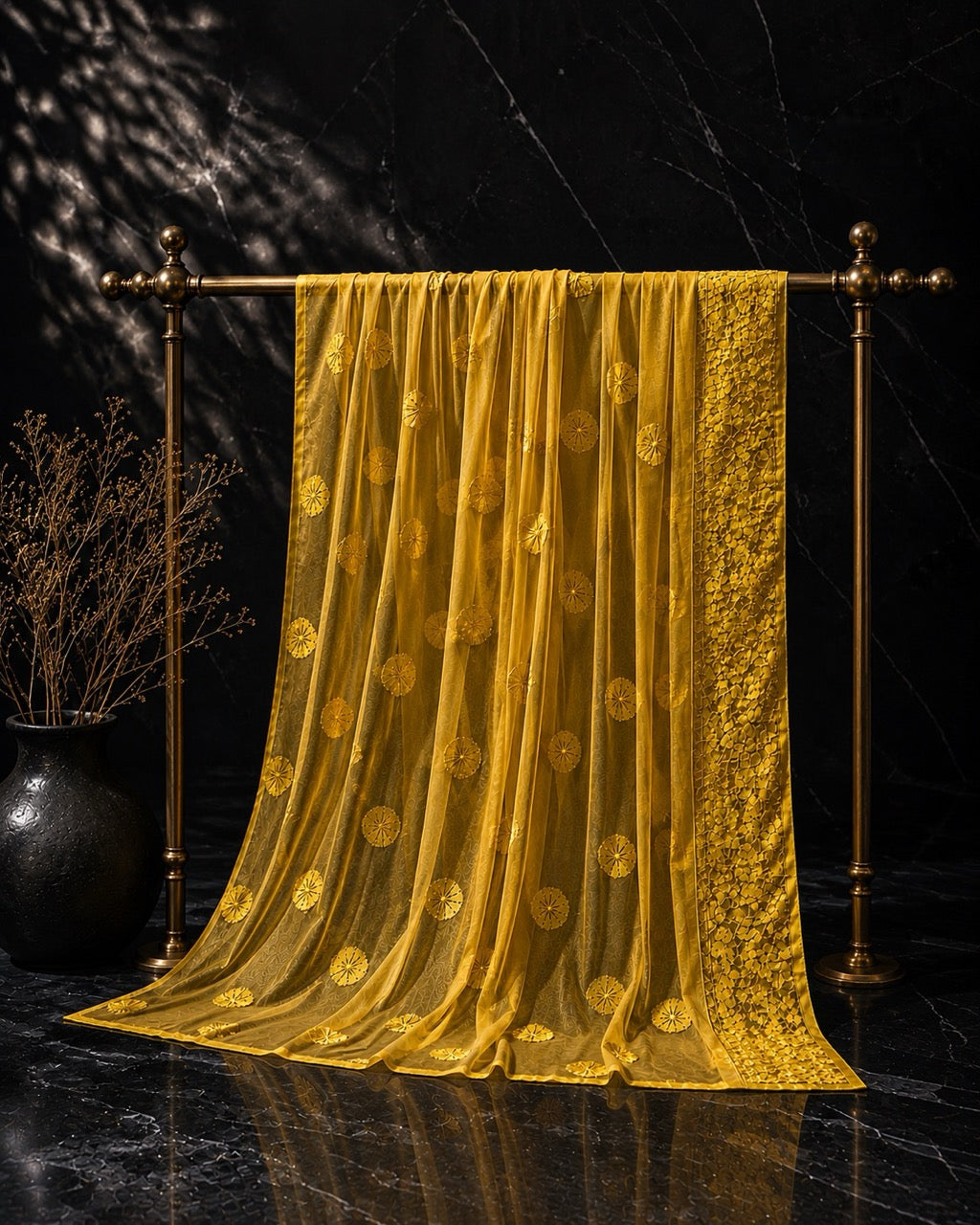 Mustard Georgette Ready to Wear Chikankari Saree, Fiesta Collection by Masnavi, hanging from a brass stand, still life.